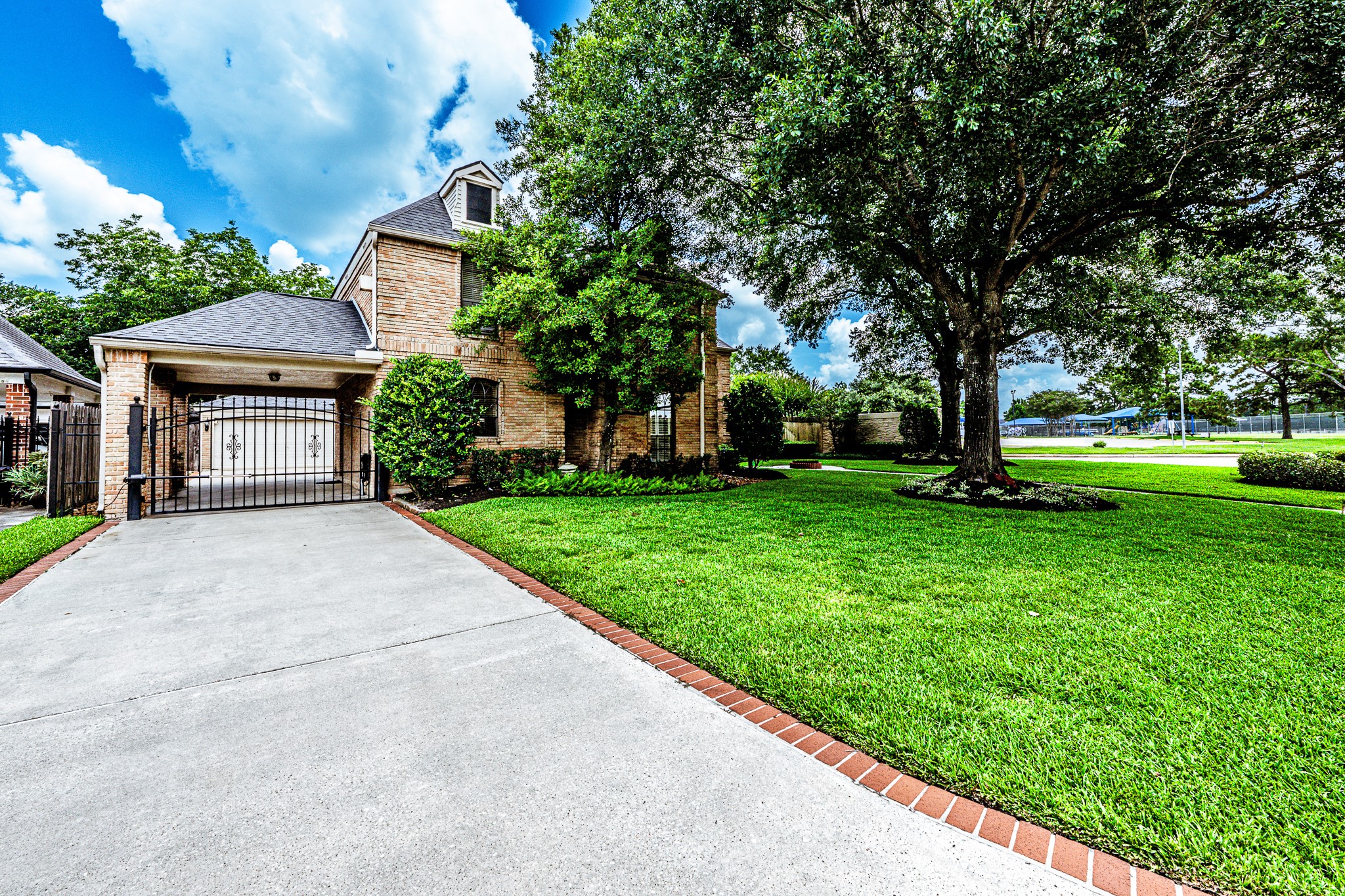 6047 Spring Creek Lane Spring, TX 77379 - Photo 47 of 50 In addition to the attached two car garage, the home features a covered porte cochère positioned beside the utility room entrance for added everyday convenience. An automatic remote controlled gate, extended drive, and generous parking areas create a welcoming arrival while offering both privacy and functionality.