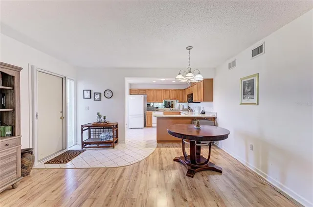 a living room with furniture and a dining table with kitchen view