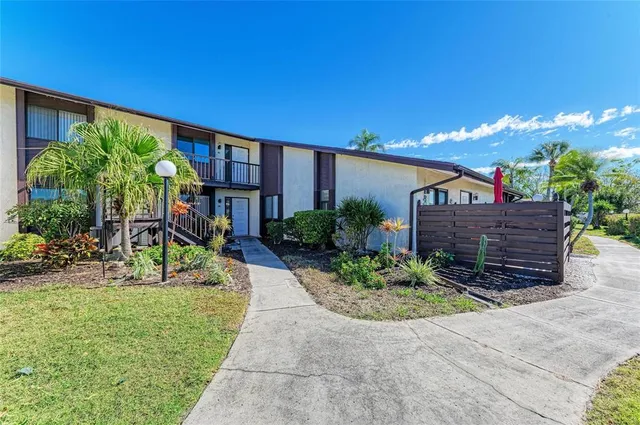 a view of a house with a yard and potted plants