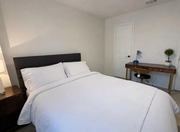 a bedroom with bed and a large window