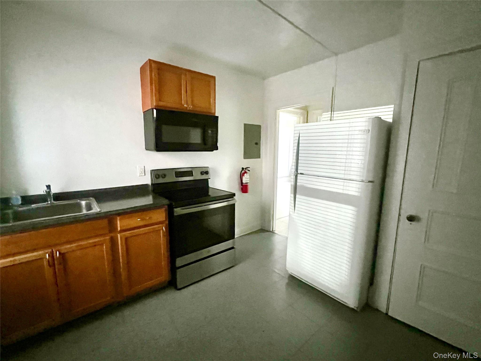101 Wickham Avenue, Unit 1 Middletown, NY 10940 - Photo 2 of 10 a kitchen with granite countertop a refrigerator and a sink