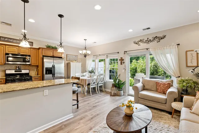 a living room with furniture kitchen view and a large window