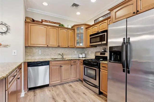a kitchen with stainless steel appliances granite countertop a stove a sink and a refrigerator