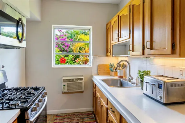 a kitchen with stainless steel appliances a stove a sink and a microwave
