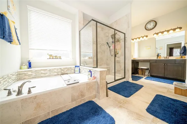 a spacious bathroom with a tub sink and mirror
