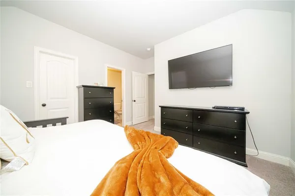 a bedroom with bed and a baby crib