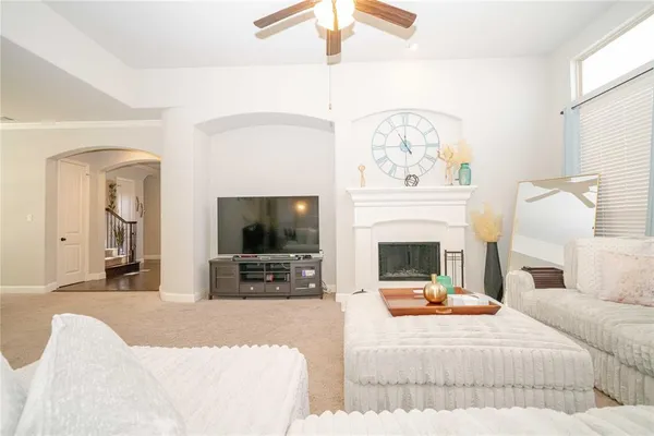 a living room with furniture a flat screen tv and a fireplace