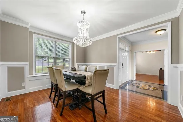 a view of a dining room with furniture a chandelier and wooden floor