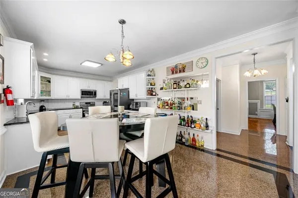 a view of a dining room and livingroom with furniture wooden floor a chandelier