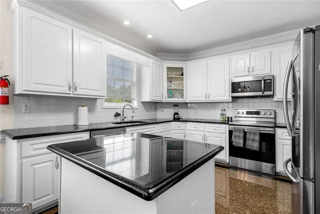 a kitchen with stainless steel appliances granite countertop a sink stove and microwave