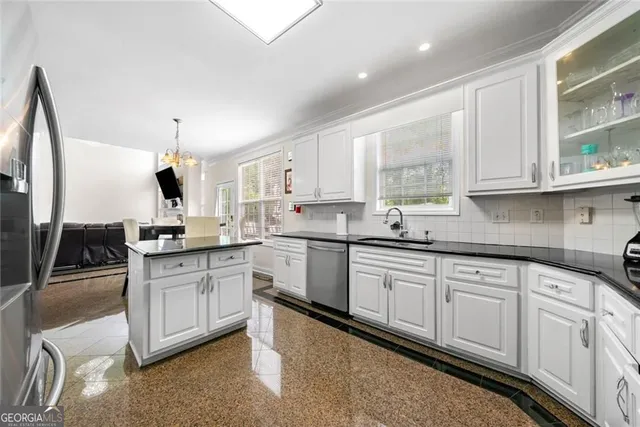 a kitchen with granite countertop a sink stainless steel appliances and cabinets