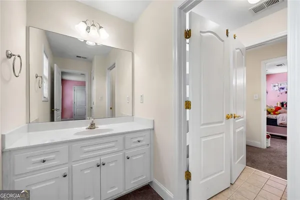 a en suite bathroom with a shower sink and mirror