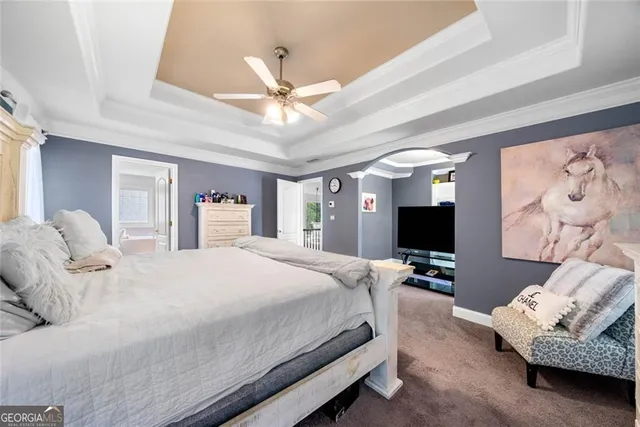 a bedroom with a bed couch and a flat screen tv