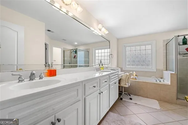 a bathroom with a tub sink and mirror