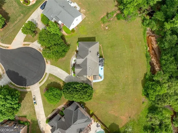 an aerial view of a house with a yard basket ball court and outdoor seating