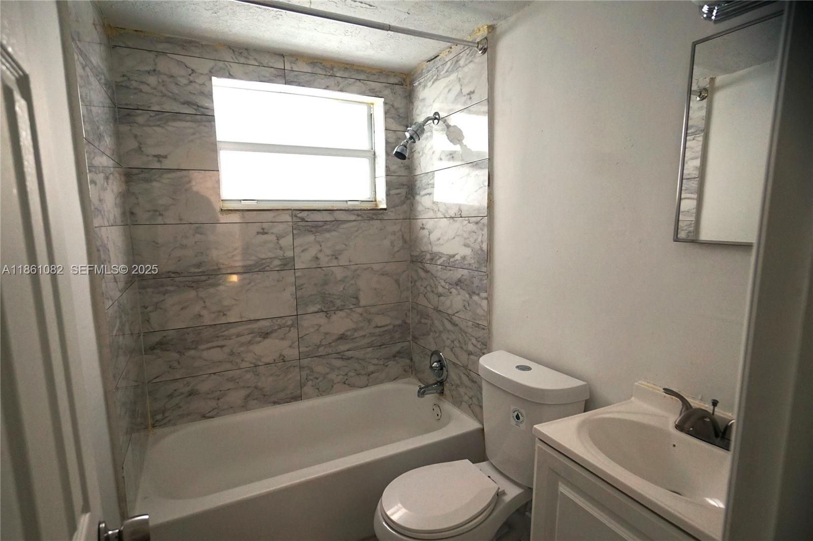 584 Northwest 65th Street, Unit 3 Miami, FL 33150 - Photo 5 of 7 a bathroom with a bathtub toilet and sink