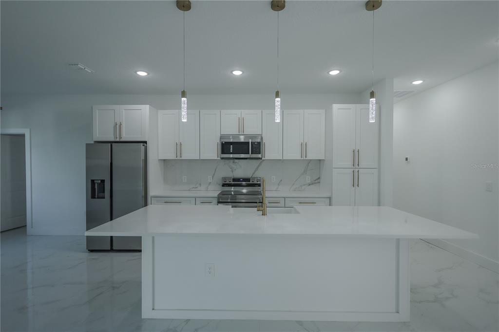 1808 Corolla Court Deltona, FL 32738 - Photo 11 of 29 a large kitchen with stainless steel appliances kitchen island a sink a stove a refrigerator and a cabinets