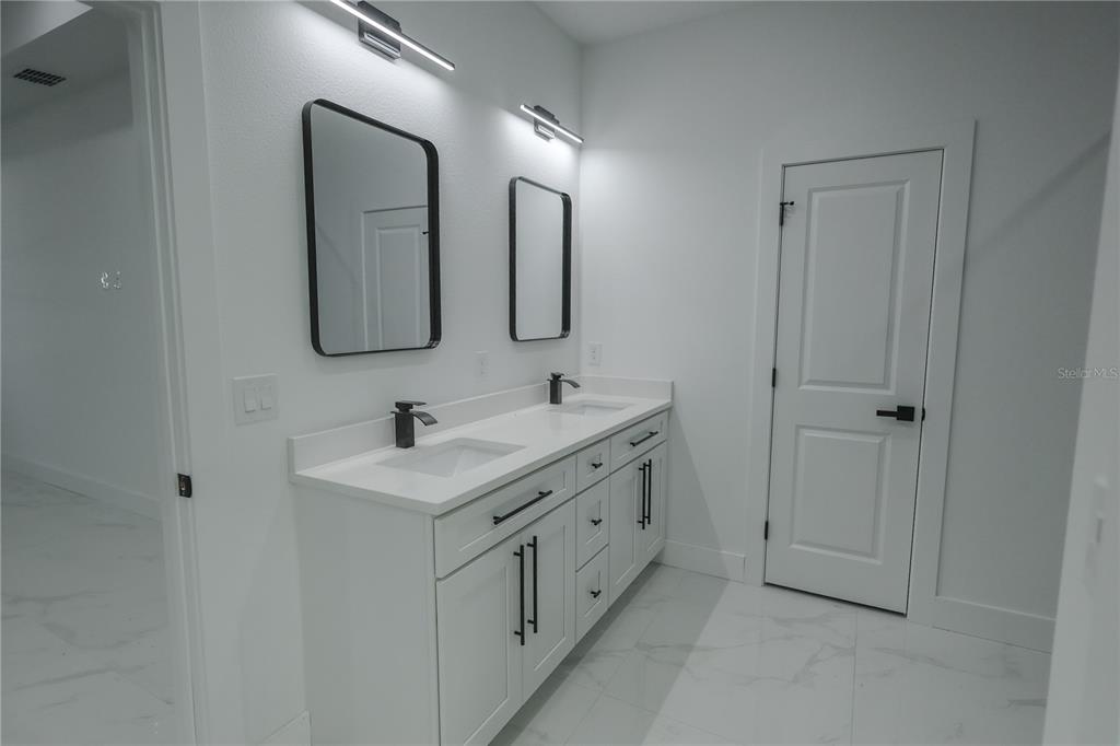 1808 Corolla Court Deltona, FL 32738 - Photo 19 of 29 a bathroom with a double vanity sink and mirror