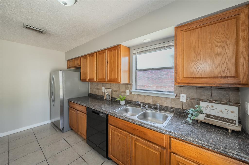 3029 Montclair Place Denton, TX 76209 - Photo 12 of 39 a kitchen with stainless steel appliances granite countertop a sink stove and cabinets