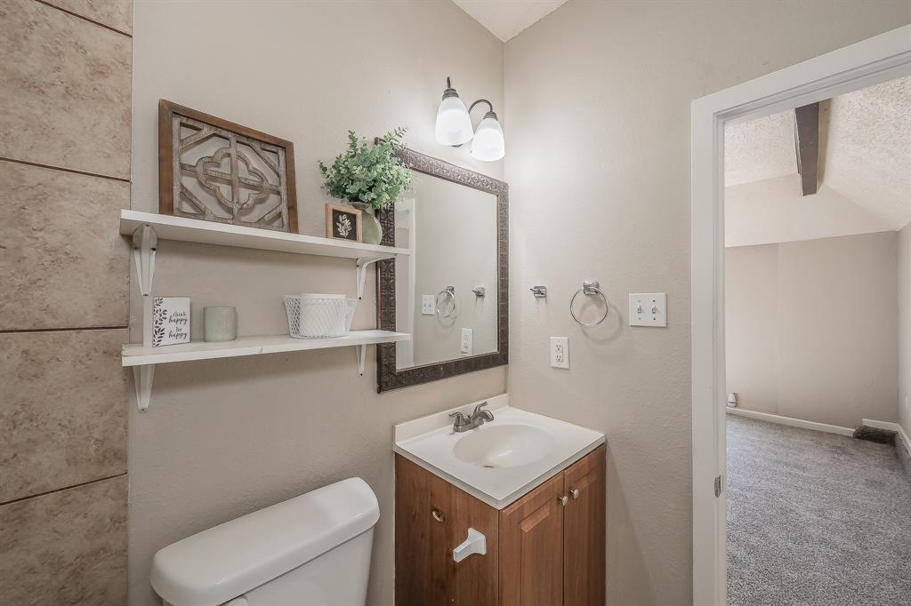3029 Montclair Place Denton, TX 76209 - Photo 20 of 39 a bathroom with a toilet a sink and mirror