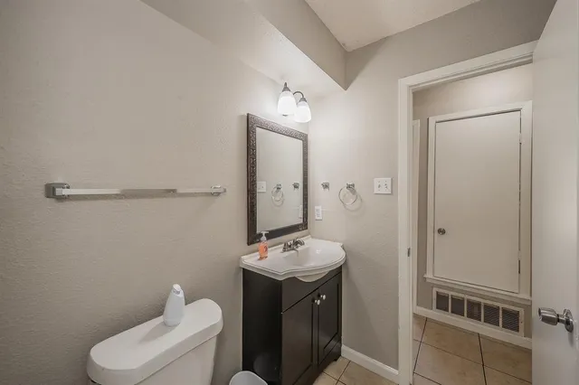 a bathroom with a bathtub shower sink mirror vanity and toilet