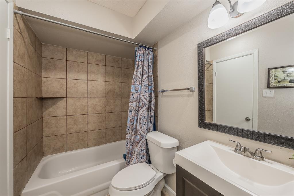 3029 Montclair Place Denton, TX 76209 - Photo 27 of 39 a bathroom with a bathtub shower sink mirror vanity and toilet