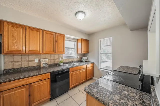 a kitchen with stainless steel appliances granite countertop a sink stove and cabinets