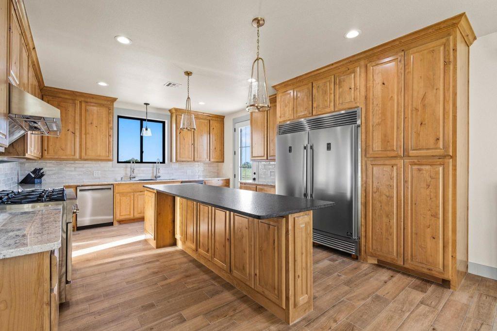4251 Refuge Road Sherman, TX 75092 - Photo 19 of 40 a large kitchen with granite countertop a large counter top a sink stainless steel appliances and cabinets