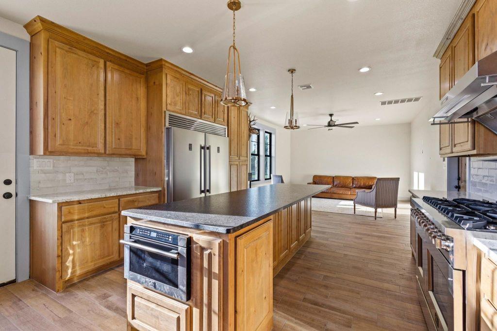 4251 Refuge Road Sherman, TX 75092 - Photo 22 of 40 a kitchen with stainless steel appliances granite countertop a stove top oven a sink dishwasher and a refrigerator with wooden floor