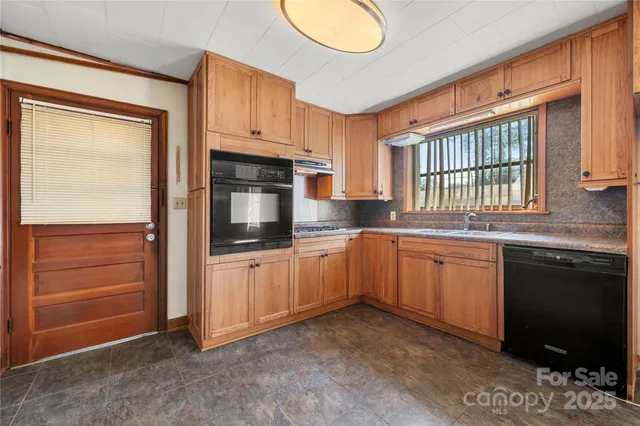a kitchen with granite countertop stainless steel appliances a stove sink and microwave