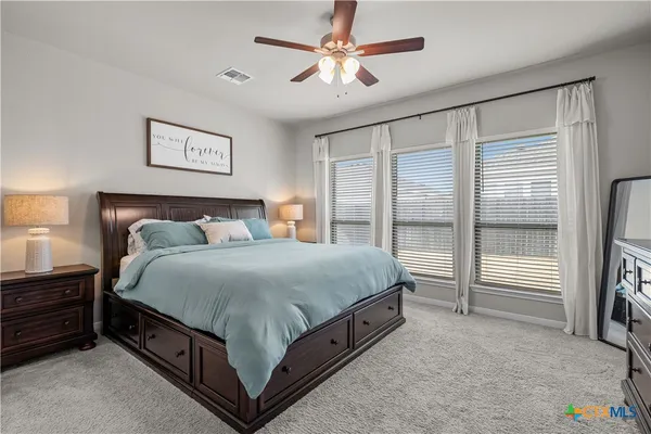 a spacious bedroom with a bed and a chandelier