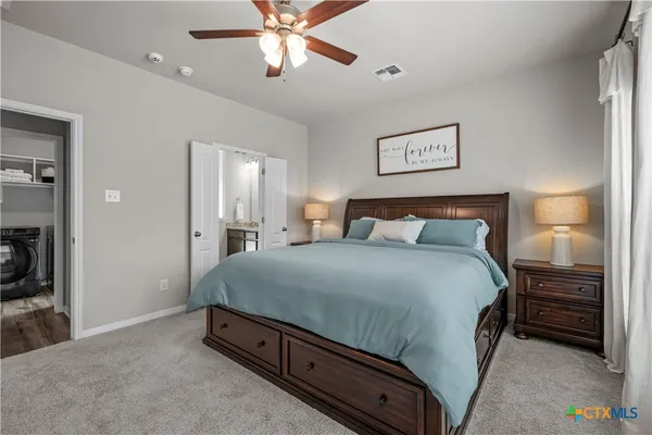 a spacious bedroom with a bed and a chandelier