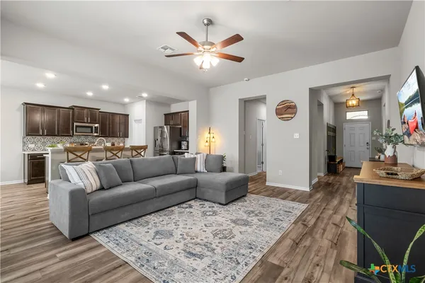 a living room with furniture and kitchen view