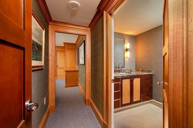 a view of a hallway with bathroom and mirror