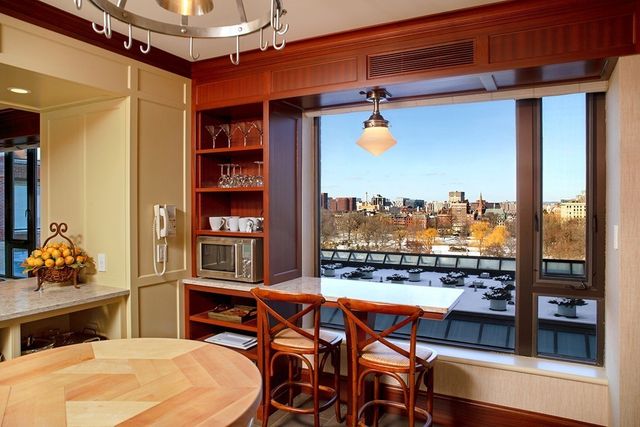 a room with stainless steel appliances kitchen island granite countertop furniture and a cabinet