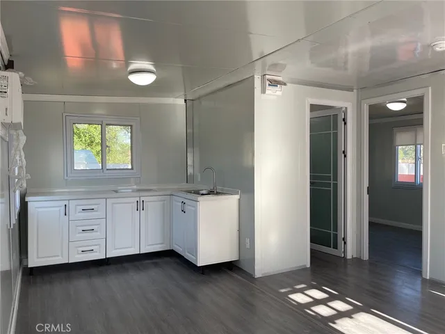 a room with white cabinets and wooden floor