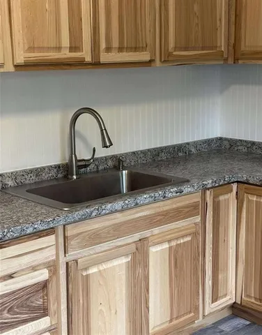 a kitchen with granite countertop a sink and cabinets