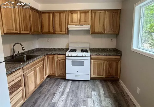 a kitchen with a stove sink and cabinets