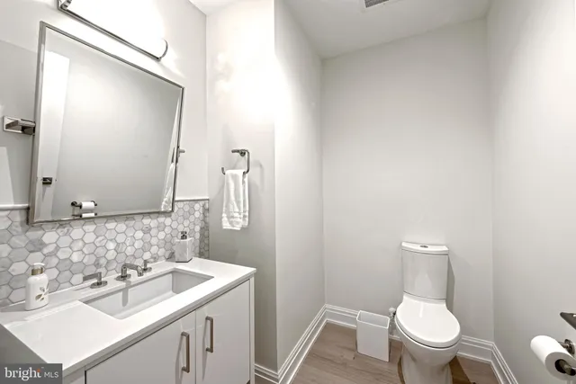 a bathroom with a sink toilet and a mirror