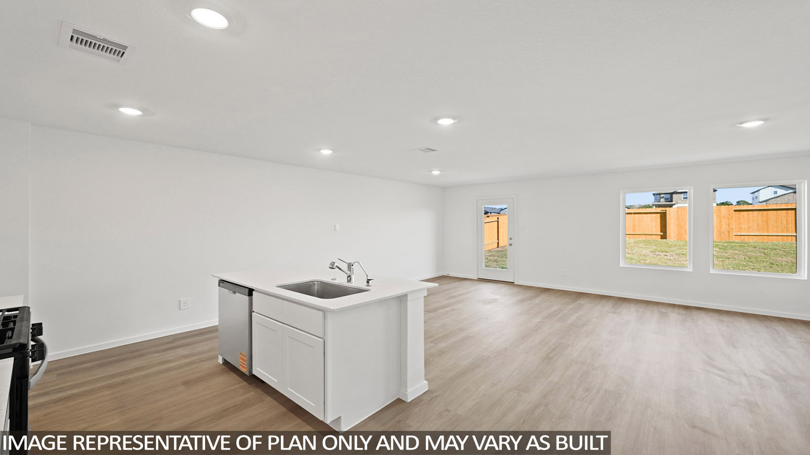 120 Baby Calf Roping Road Jarrell, TX 76537 - Photo 6 of 27 A well-lit interior features a central kitchen island and durable flooring leading to the backyard.