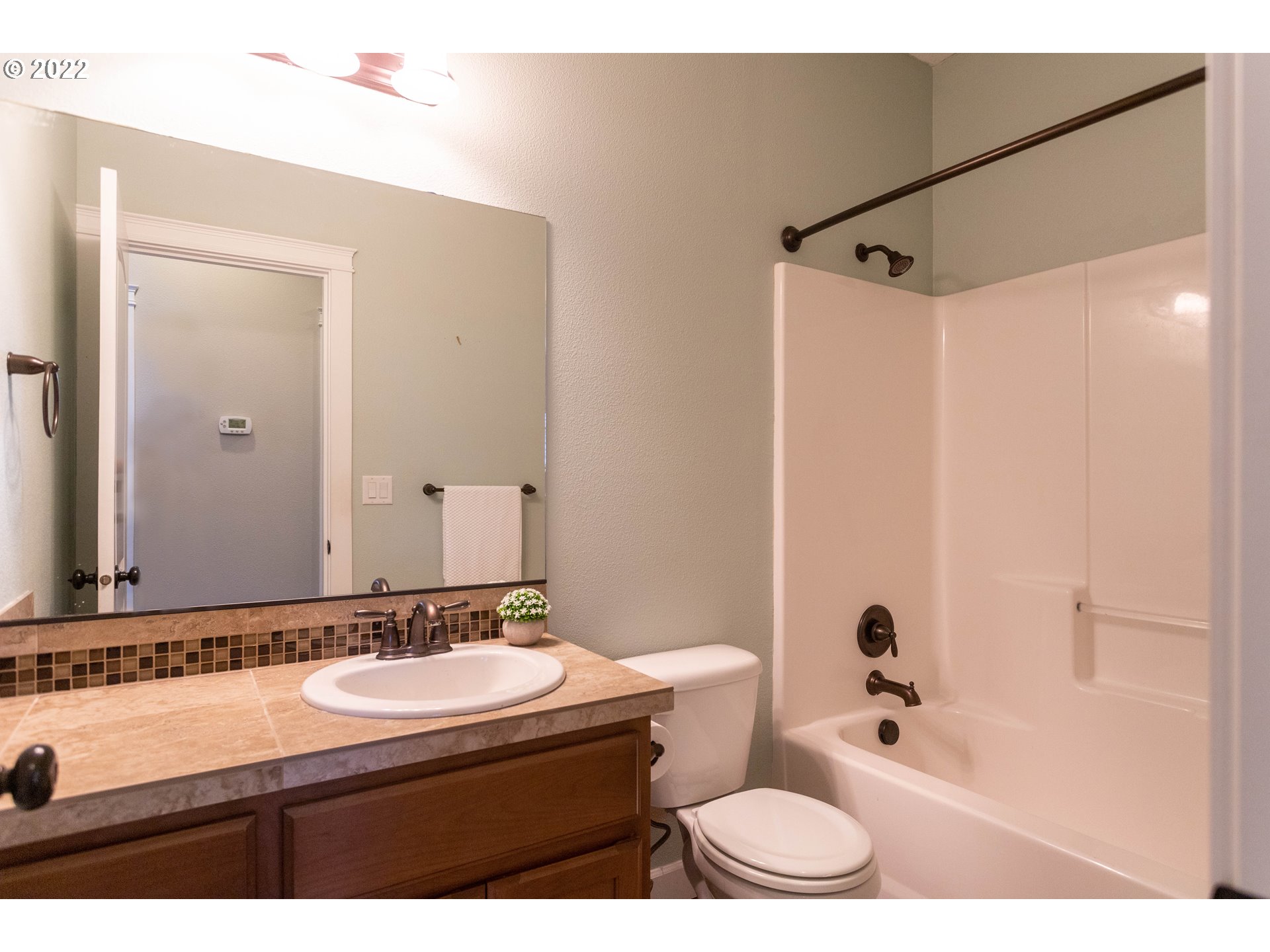 1914 South Sevier Road Ridgefield, WA 98642 - Photo 11 of 25 a bathroom with a sink a toilet a mirror a bathtub and shower