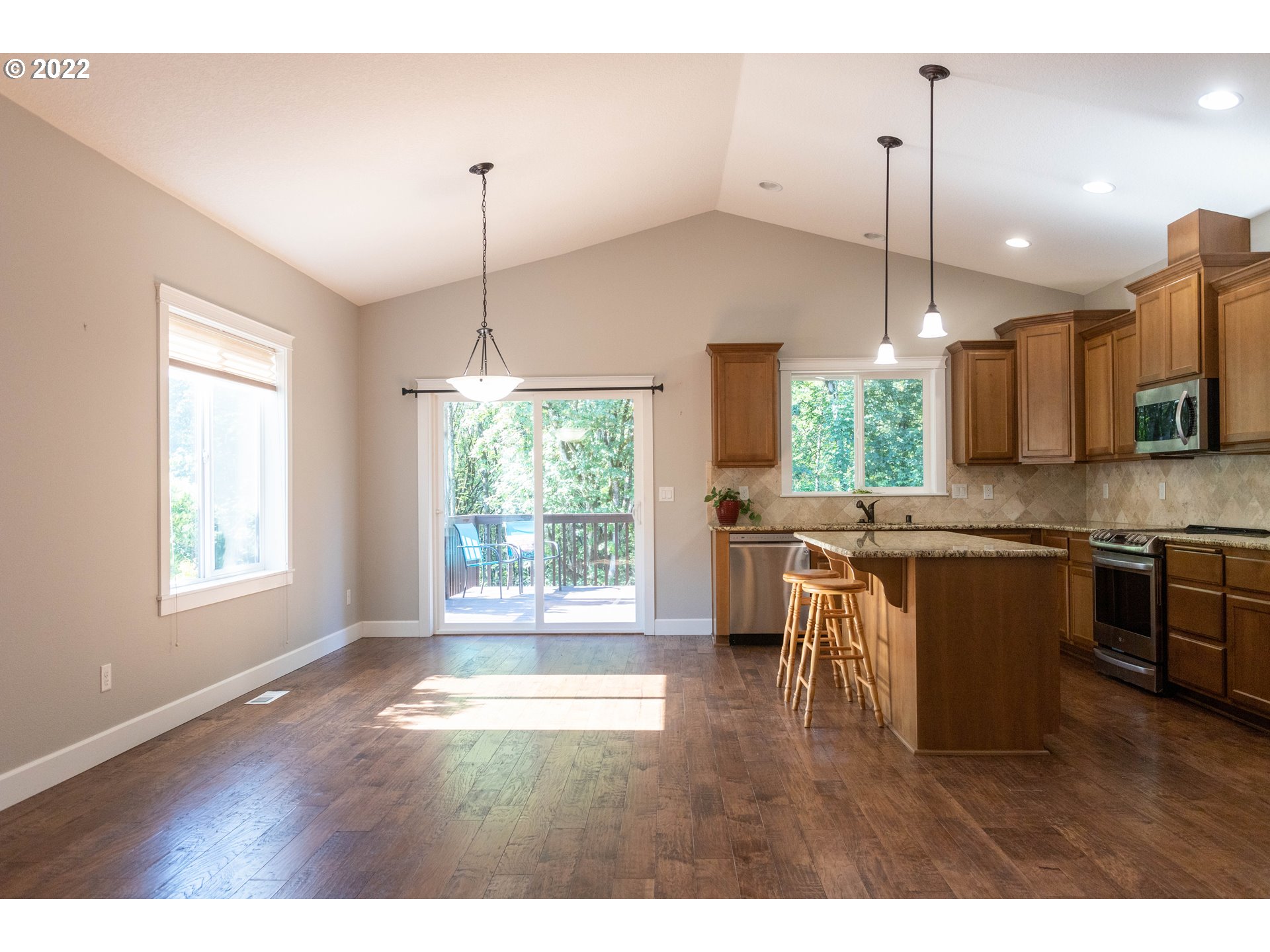 1914 South Sevier Road Ridgefield, WA 98642 - Photo 3 of 25 a kitchen with kitchen island granite countertop a stove a sink a center island and a wooden floor