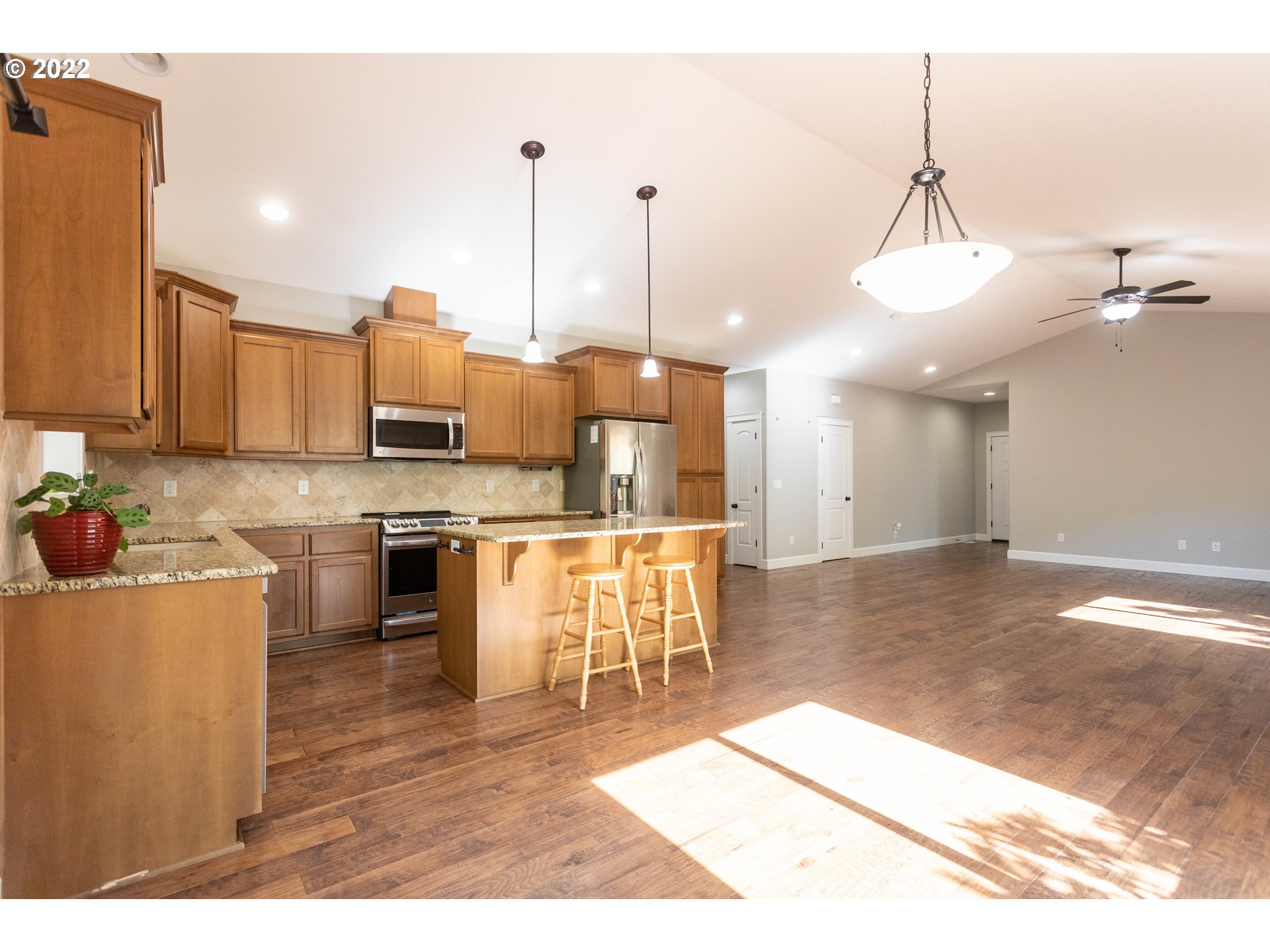 1914 South Sevier Road Ridgefield, WA 98642 - Photo 6 of 25 a open kitchen with stainless steel appliances kitchen island granite countertop a stove a sink a refrigerator and a granite counter top