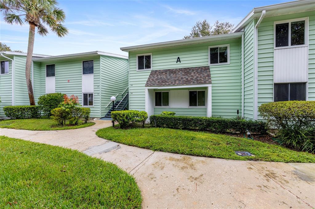 606 Midway Drive, Unit A Ocala, FL 34472 - Photo 2 of 27 a front view of a house with a yard and potted plants