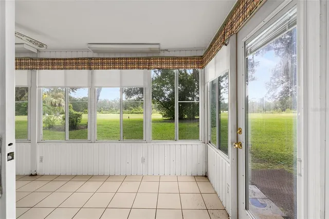 a living room with furniture and floor to ceiling windows