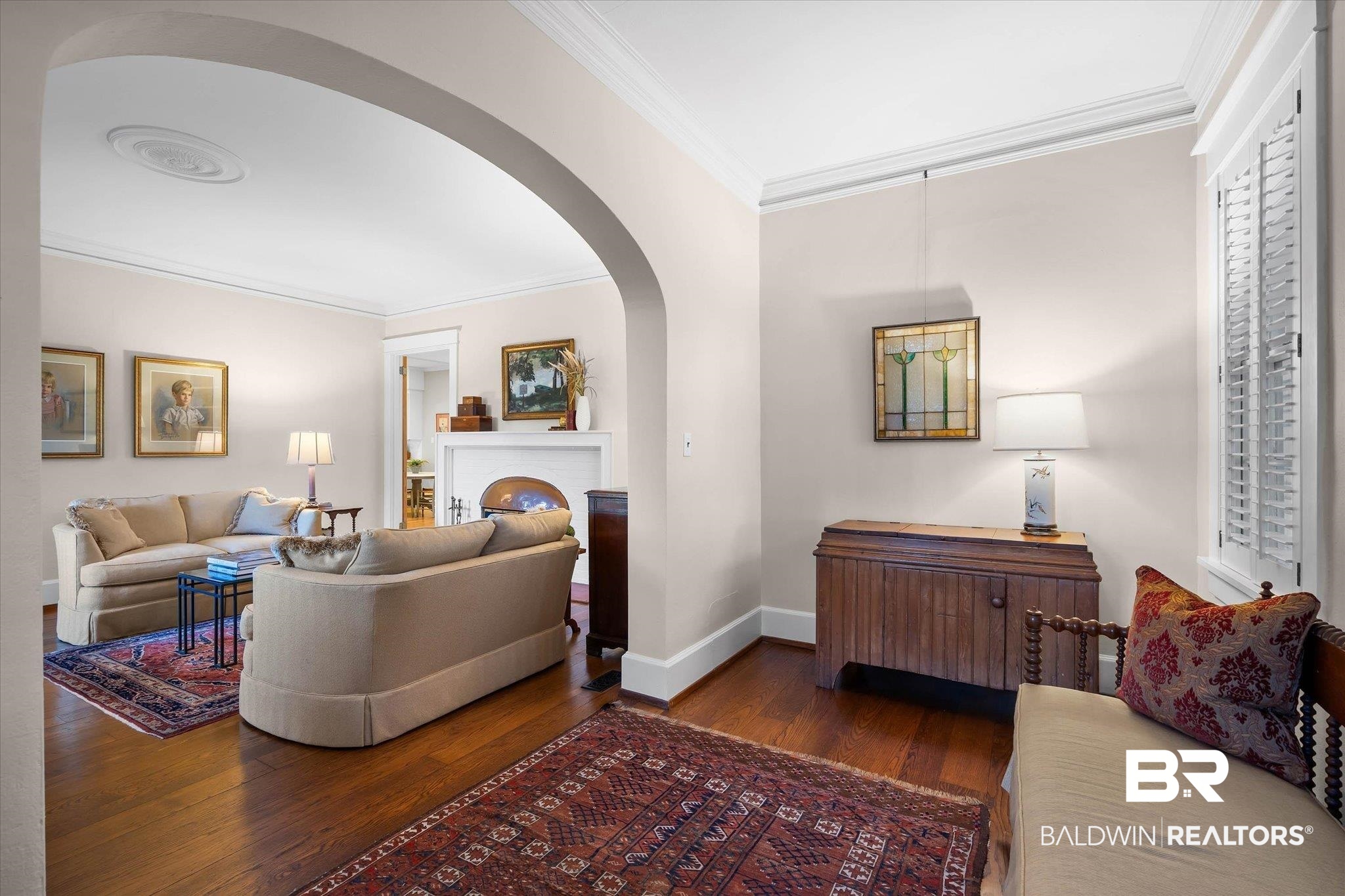 2 Westgate Road Mobile, AL 36608 - Photo 10 of 63 Living area with ornamental molding, dark wood-style floors, arched walkways, and a brick fireplace