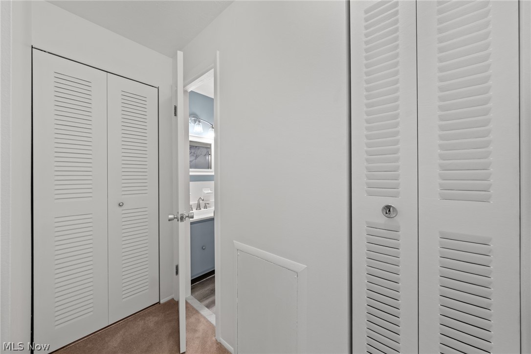 3070 Kent Road, Unit 312D Stow, OH 44224 - Photo 27 of 49 Hallway featuring louvered closet doors with hardware, wood-finish flooring, and clean white walls with smooth drywall finish
