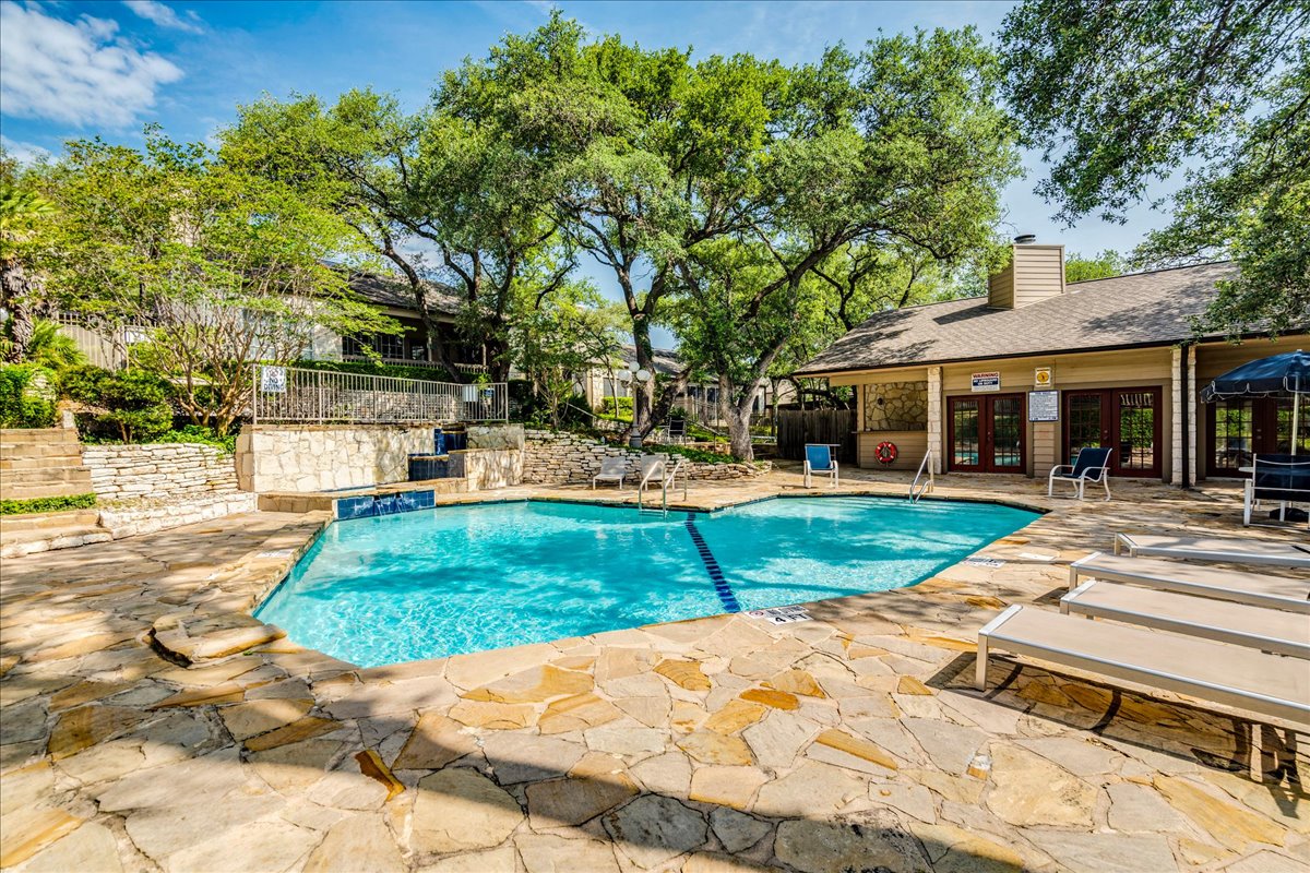 3809 Spicewood Springs Road, Unit 127 Austin, TX 78759 - Photo 27 of 29 A refreshing outdoor pool, surrounded by natural stone paving, offers a relaxing oasis within the community.