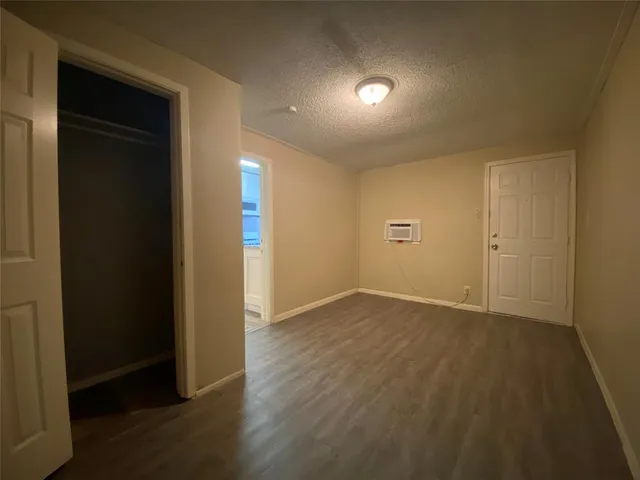 an empty room with wooden floor and closet
