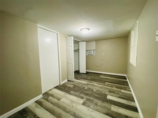 a view of room with window and wooden floor